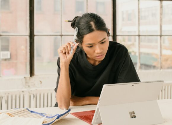 a woman sitting at a table using a laptop computer